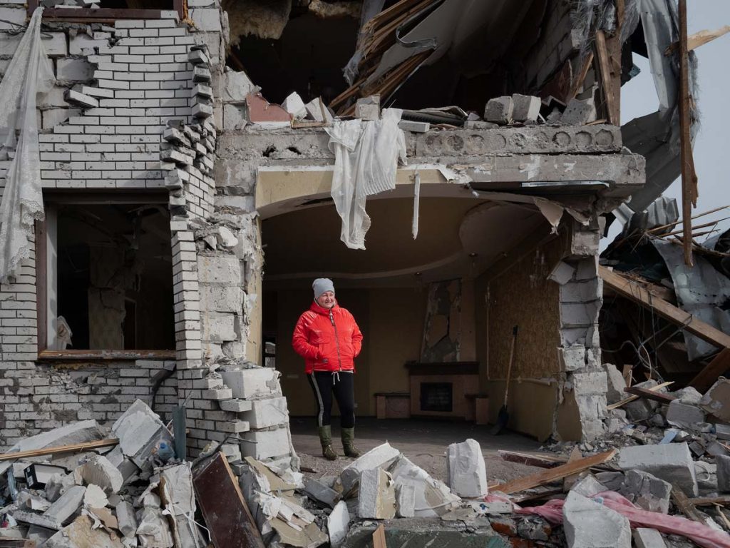 Une femme pose dans les restes de sa maison détruite par les bombardements russes à Ovruch, un village proche de Korosten, dans la région de Tchernobyl.